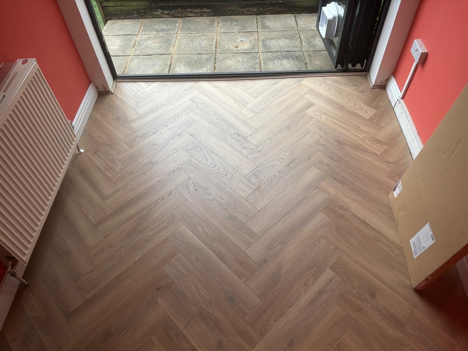Newly laid herringbone floor next to sliding glass doors