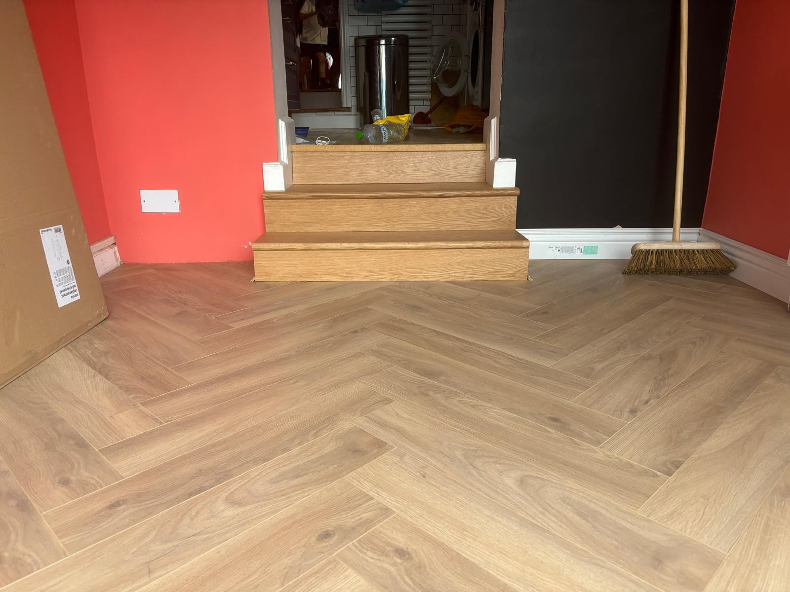 Oak stair treads meeting a herringbone floor